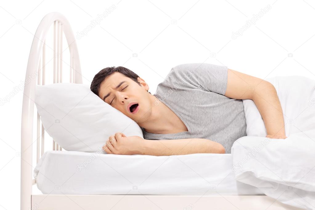 Young guy sleeping on a bed