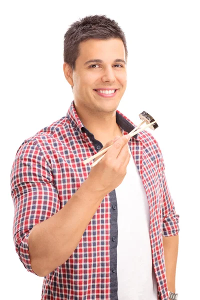 Man eating sushi with Chinese sticks — Stock Photo, Image