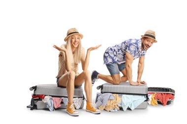 Çift, bavullarını doldurup beyaz arka planda tek başına gülüyor.