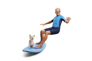 Dalış kıyafetli yaşlı bir adam beyaz arka planda izole edilmiş bir köpekle sörf tahtası sürüyor.