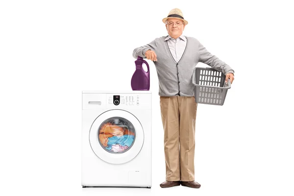 Senior man next to a washing machine — Stock Photo, Image