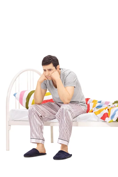 Worried man sitting on a bed and contemplating — Stock Photo, Image