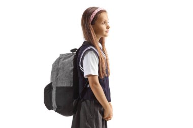 Üniformalı kız öğrenci sırt çantasıyla beyaz arka planda izole edilmiş bir şekilde duruyor.