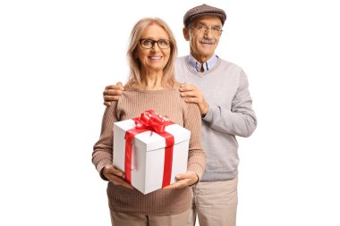 Olgun erkek ve kadın beyaz arka planda izole edilmiş bir hediye kutusuyla dikiliyorlar.