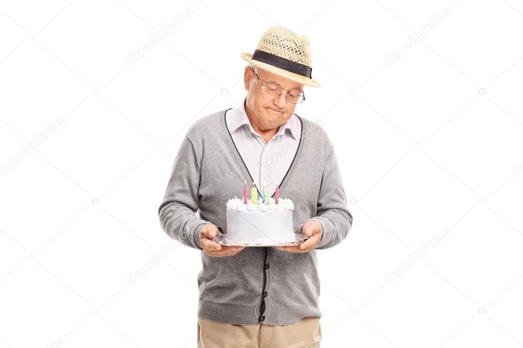 senior gentleman holding a birthday cake