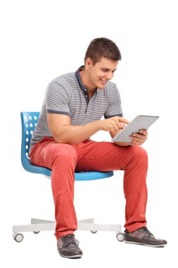 Young man sitting and working on a tablet