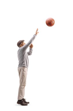 Beyazların arka planında izole edilmiş basketbol oynayan üst düzey bir adamın tam boy profil çekimi.