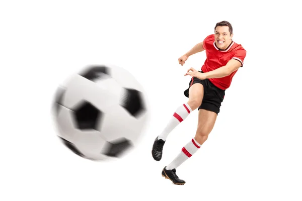 Jeune footballeur donnant un coup de pied à un ballon — Photo