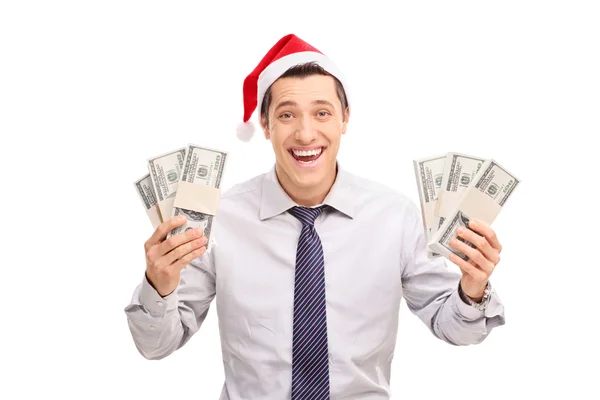 Человек в шляпе Санта-Клауса держит деньги — стоковое фото
