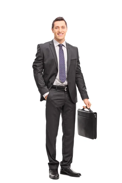 Young businessman in a suit holding a briefcase — Stock fotografie