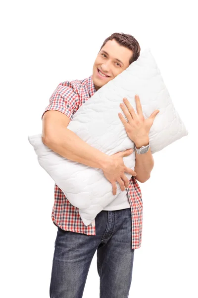 Young man hugging a pillow — Stockfoto