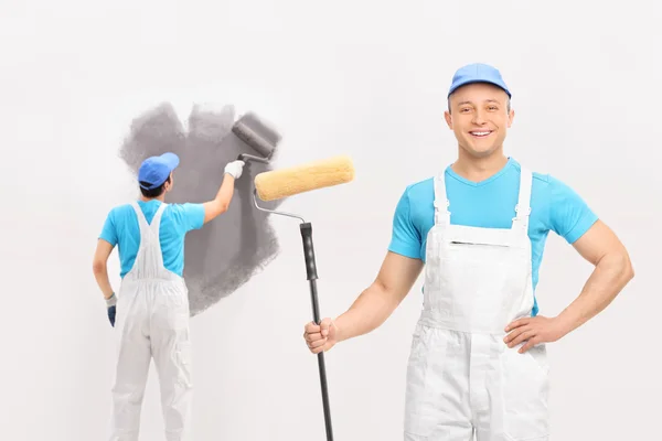 Dos pintores masculinos pintando una pared — Foto de Stock