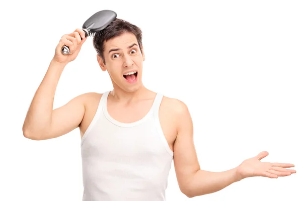 Angry young man brushing his hair — Stock Photo, Image