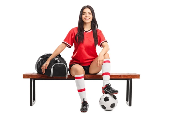 Jogador de futebol feminino sentado em um banco — Fotografia de Stock