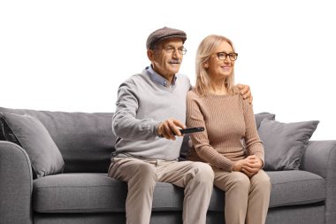 Yetişkin çift birlikte televizyon izliyor ve uzaktan kumandayı beyaz arka planda tutuyorlar.