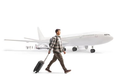Genç bir adamın bavul çekip beyaz arka planda izole edilmiş bir uçağa binerken tam boy profil fotoğrafı.