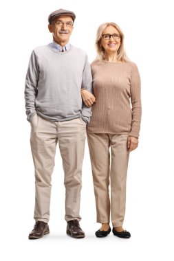 Olgun çift, beyaz arka planda izole edilmiş kol kola mutlu poz veriyor.