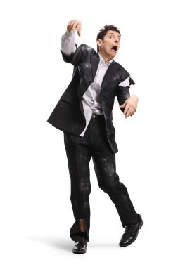 Beyaz arka planda, kirli yırtık bir takım elbise giymiş zombi gibi yürüyen bir adam.