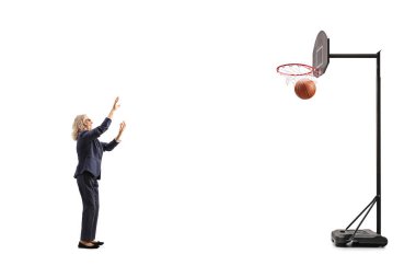 Basketbol oynayan olgun iş kadını beyaz arka planda izole edilmiş