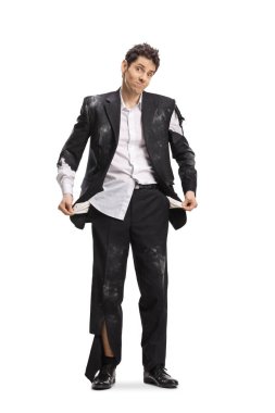 Eski yırtık elbiseli şanssız bir adam beyaz arka planda boş ceplerini gösteriyor.