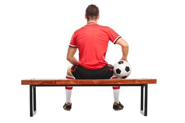 Football player with ball sitting on a bench — Φωτογραφία Αρχείου