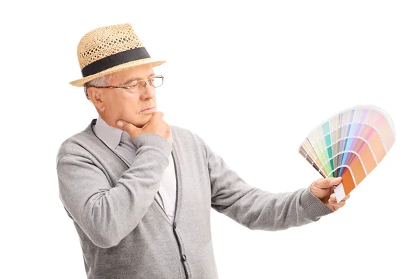 Старший джентльмен смотрит на цветные образцы — стоковое фото