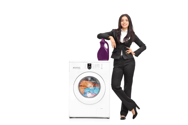 Businesswoman standing by a washing machine — Stock Photo, Image