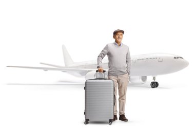 Beyaz arka planda izole edilmiş bir uçağın önünde bavulla duran son sınıf erkek yolcu.