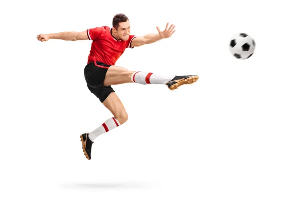 Piłkarz kopiąc piłkę — Zdjęcie stockowe