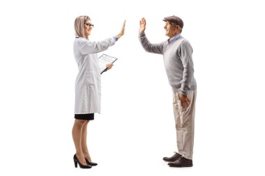 Kadın doktor beyaz arka planda tecrit edilmiş yaşlı bir erkek hastaya beşlik çakıyor.