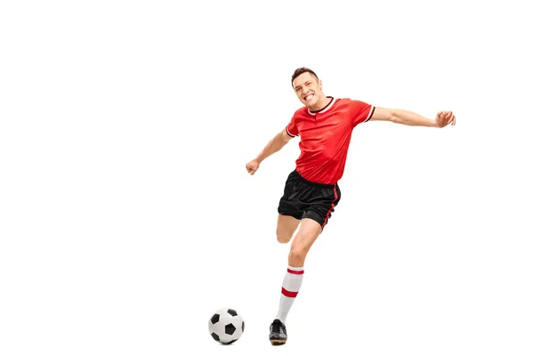 Young football player kicking a ball — Stock Photo, Image