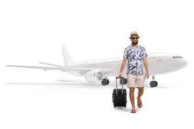 Uçaktan inen ve beyaz arka planda izole edilmiş bir bavulu çeken bir erkek turistin tam boy portresi