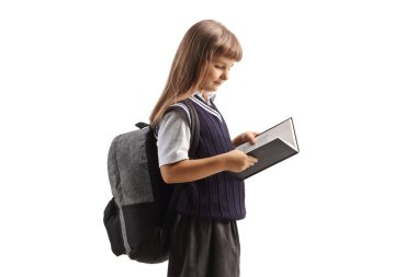 Okul üniformalı bir çocuk beyaz arka planda izole edilmiş bir kitap okuyor.