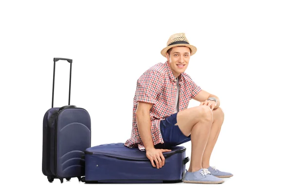 Male tourist sitting on his baggage — Stock fotografie