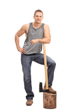 Muscular man leaning over an axe