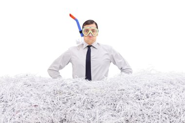 Businessman with snorkel standing in shredded paper
