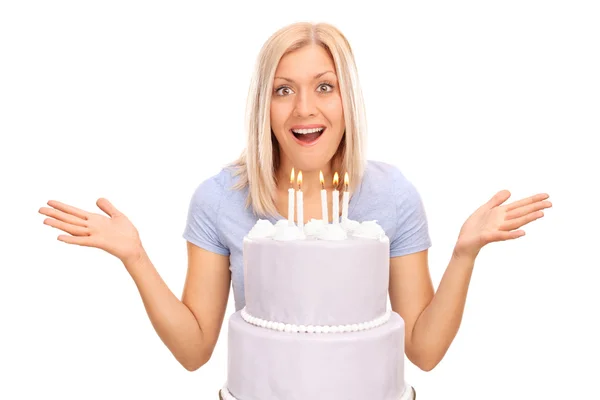 Surprised woman behind a birthday cake — Stok fotoğraf