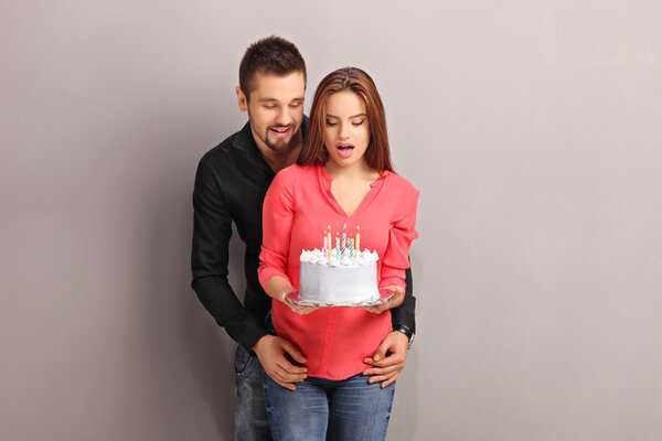 girl holding a cake with her boyfriend