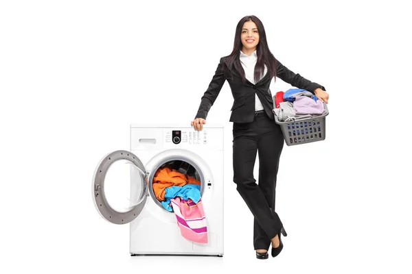 Businesswoman standing by a washing machine — Stock Photo, Image