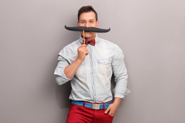 Cheerful young man with fake moustache