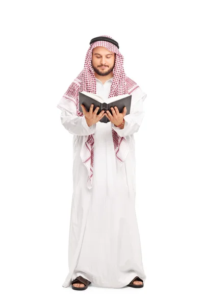 Arab in a white robe reading a book — Stockfoto