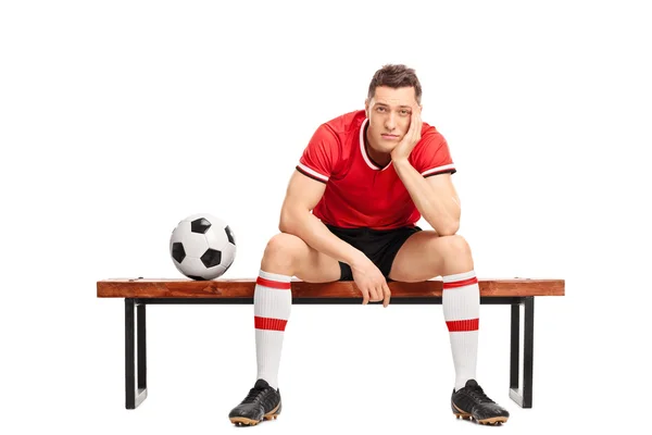 Triste jugador de fútbol sentado en un banco —  Fotos de Stock