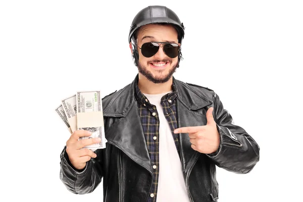 Biker holding few stacks of money — Stockfoto