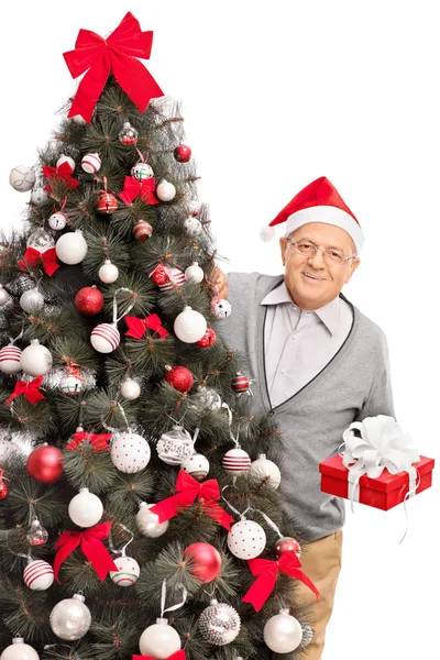 Hombre mayor detrás de un árbol de Navidad — Foto de Stock