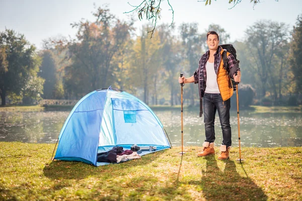 Wandelaar poseren door een vijver naast tent — Stockfoto