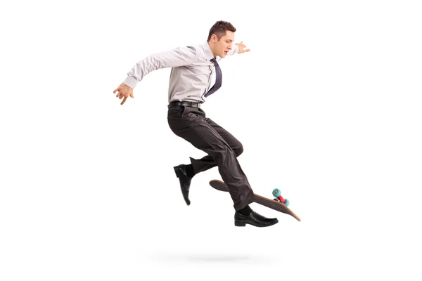 Skillful businessman performing trick on skateboard — Stockfoto