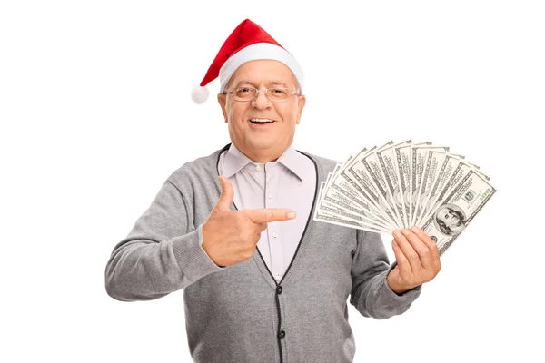 Старший чоловік з Санта-капелюхом тримає гроші — стокове фото