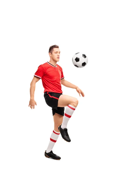 Молодой футболист жонглирует мячом — стоковое фото