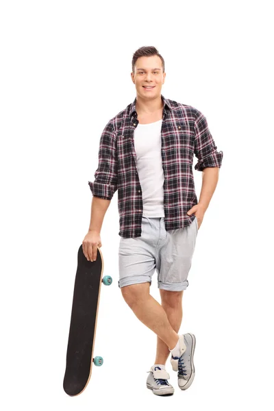 Skater di sesso maschile appoggiato sul suo skateboard — Foto Stock