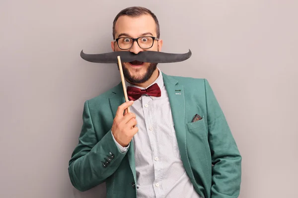 Excited man holding a fake mustache — Stock fotografie